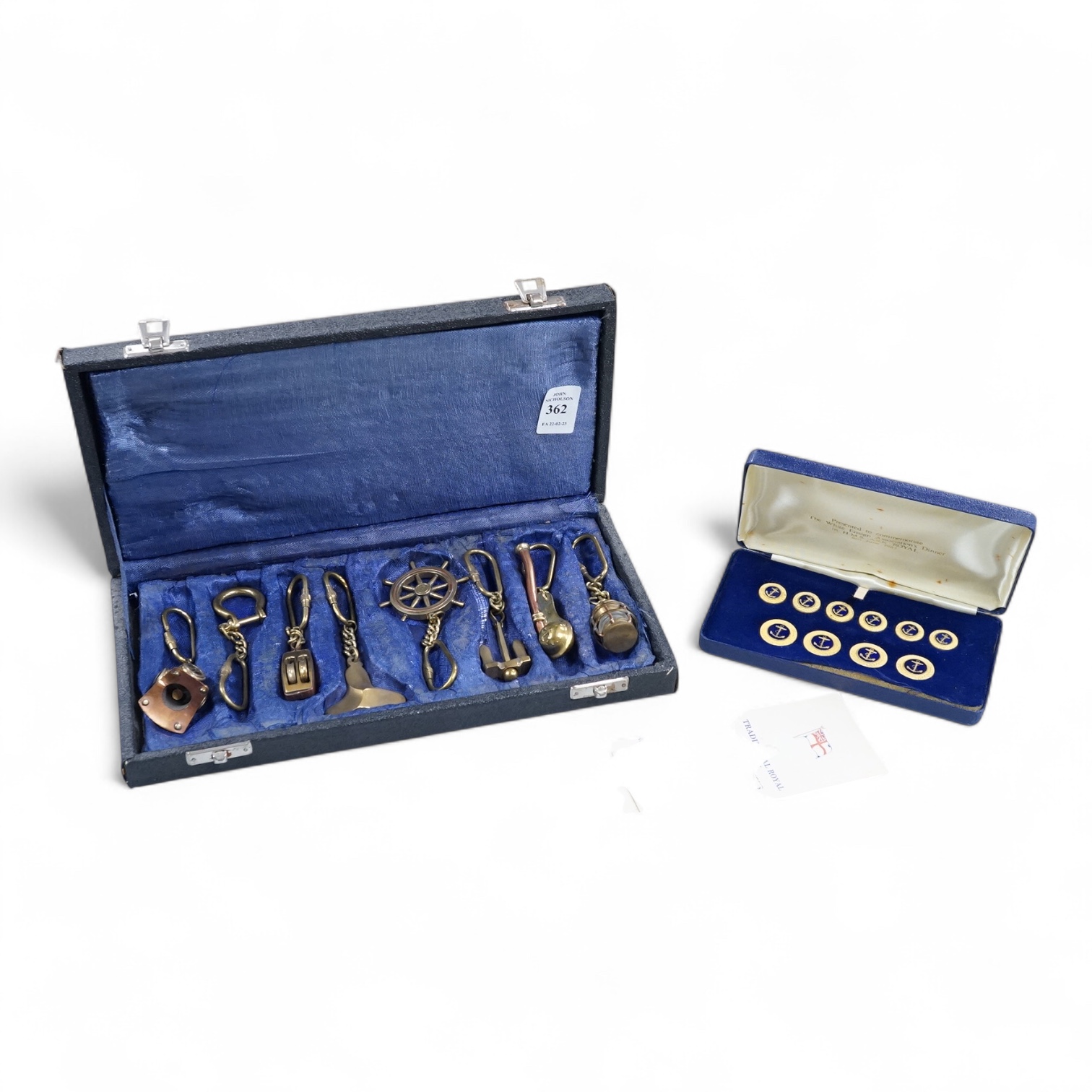 A cased set of enamelled naval buttons and similar keyrings